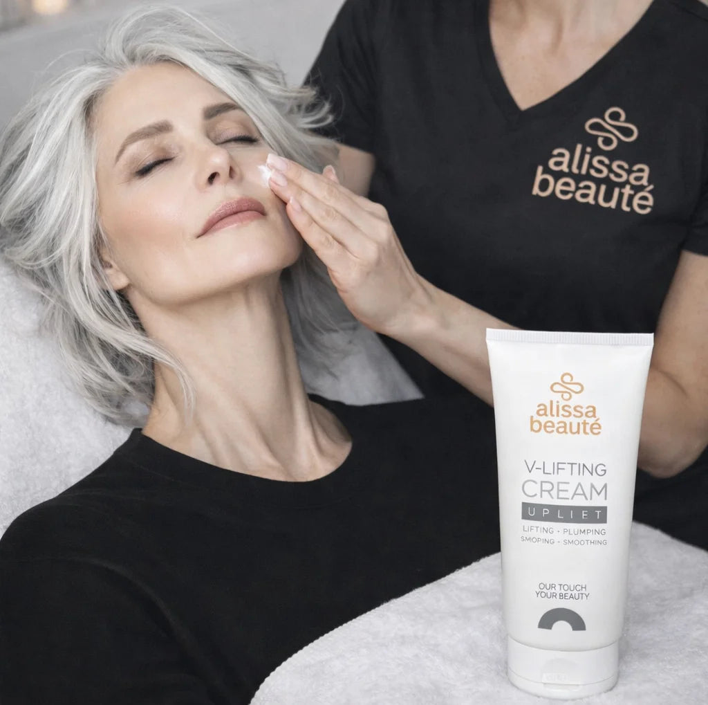 cosmetician masând V-Lifting Cream Alissa Beauté pe obraz cu mișcări ascendente de lifting, flacon alb vizibil în mână. Cremă cu Centella Reversa, Biollagen colagen vegan și Trehalose pentru ten matur-uscat, linia UPLIFT.
